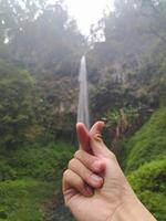 Malang, Indonesia, Oct 22, 2023 - View of human hands and Watu Ondo waterfall, Malang photo