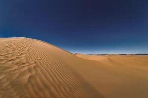 A panoramic sand dune of sahara desert at Mhamid el Ghizlane in Morocco wide shot photo