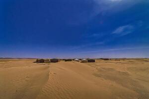 A panoramic sand dune near the desert camp at Mhamid el Ghizlane in Morocco wide shot photo