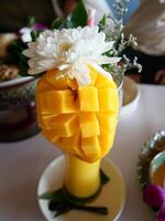 Mango smoothie and the glass was decorated with yellow mango pulp and white flower photo