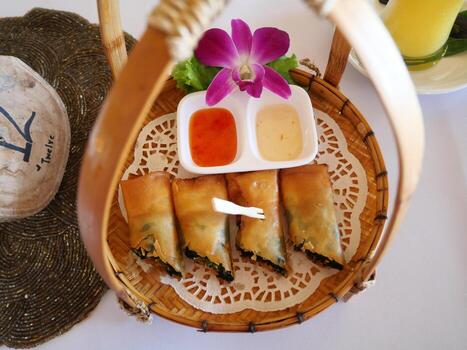 Fried spring rolls stuffed with spinach Placed in a basket on the dining table photo