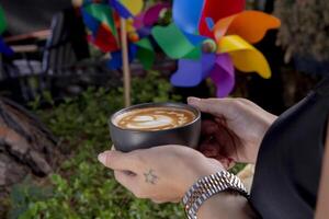 Frothy coffee in black cup, cup of coffee. photo