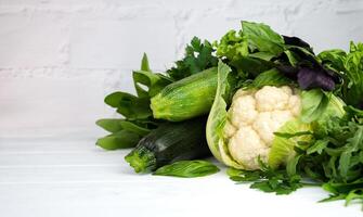 Fresh green vegetables on white wooden background. Healthy diet concept. Copy space. Selective focus. photo