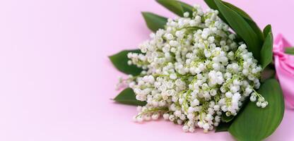 Bouquet lilies of the valley on a pink background. Congratulatory card. Copy space. Selective focus. photo