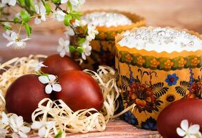 Festive composition with colored eggs and Easter cakes decorated with white icing. Close-up. Selective focus. photo