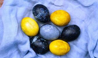 Colorful Easter eggs painted in yellow and blue. Coloring eggs for Easter with natural food coloring turmeric and hibiscus tea at home. Close-up. Top view. photo