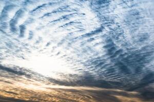 Beautiful striated cloud formation in sky looking like fluffy waves, weather forecast photo