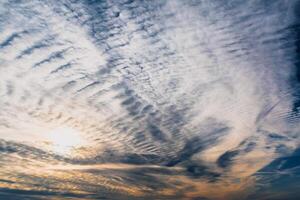 Beautiful striated cloud formation in sky looking like fluffy waves, weather forecast photo