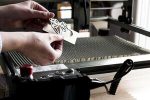 Laser engraving and cutting, woman holding an example of a cut out wooden heart photo