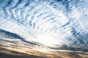 Beautiful striated cloud formation in sky looking like fluffy waves, weather forecast photo