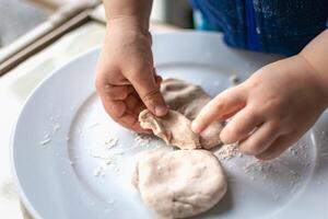 Child having fun modeling dough, authentic activity for fine motor skills development photo