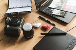 Graphic designer workstation with dslr, lens, laptop, agenda, stylus and 3d objects photo