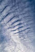 Beautiful striated cloud formation in sky looking like fluffy waves, weather forecast photo