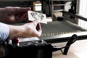 Laser engraving and cutting, woman holding an example of a cut out wooden heart photo