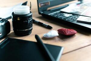 Graphic designer workstation with dslr, lens, laptop, agenda, stylus and 3d objects photo