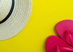 Flatlay, summer vacation. Hat and sandals on a yellow background. photo