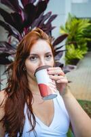 latina mujer Bebiendo un taza de café fuera de en el jardín. foto