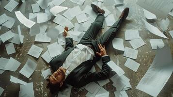 AI generated AI Generated exhausted businessman lying down on the ground with huge of flying documents and paper. photo