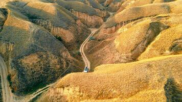 Aerial view Cars traveling in the canyon on a dirt road between large sand mountains. Incredible canyon landscape in the national park. video