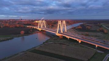 aéreo ver tráfico Moviente en el puente a oscuridad en el ciudad de Cracovia en Polonia. de cerca de un moderno atirantado puente intrincado arquitectura en contra el fondo de un crepúsculo cielo en Cracovia. video