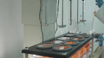 Laboratory technician in protective clothing taking chemical samples from automatic mixer in laboratory video