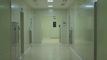 People in protective clothing of chemists walking down the corridor of the laboratory video