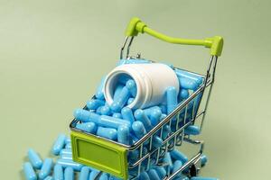 blue medicine capsule in miniature shopping cart photo