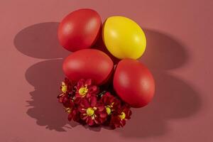 Colorful eggs, symbolizing Easter, on a colorful background and flowers photo