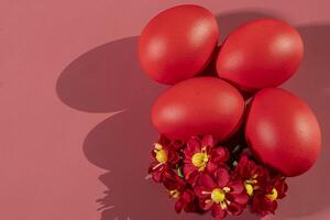 Colorful eggs, symbolizing Easter, on a colorful background and flowers photo