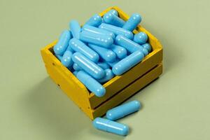 blue medicine capsule in miniature shopping cart photo