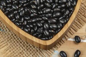 heart shaped black bean bowl on wooden table photo