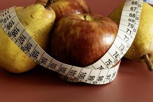 Tape measure and apple symbolizing diet and obesity photo
