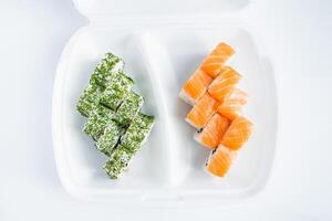 Philadelphia roll in plastic container on white background. Uramaki rolls. photo