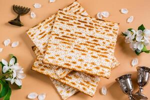Happy Passover. Traditional Jewish holiday. Silver wine cups, spring flowers and matzo bread photo