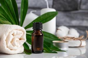 Essential oil, towel and candles on gray stone background. Spa wellness accessories and cosmetics. photo