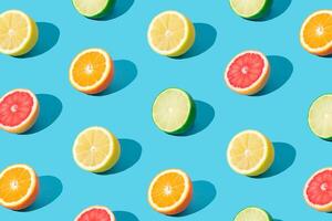 Colorful sunlight fruit pattern made of red grapefruit, orange, lime and lemon slices on light blue background. Minimal summer concept. Creative food idea. Citrus fruits aesthetic. Trendy colors idea. photo