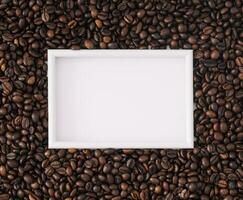 Roasted coffee beans background with white frame copy space. Minimal concept and simplicity. Coffee aesthetic background. Flat lay, top of view. photo