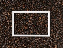 Roasted coffee beans background with white frame copy space. Minimal concept and simplicity. Coffee aesthetic background. Flat lay, top of view. photo