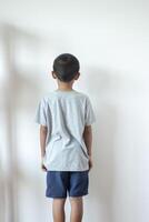 Boy and girls standing in front of the wall in the corner of the roomBecause of being punished by parents. photo