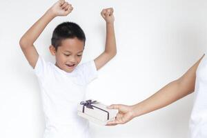 mamá dando un regalo a su hijo, contento pequeño chico foto