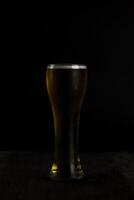 Glass of beer on dark background photo