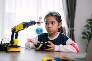 asiático muchachas fueron aprendizaje robot programación y consiguiendo lecciones controlar en robot brazos. laboratorio. matemáticas, ingeniería, ciencia, tecnología, computadora código, codificación. vástago educación. foto