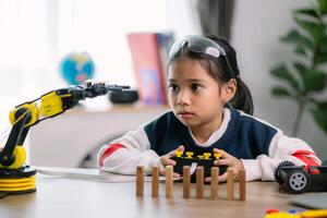 asiático muchachas fueron aprendizaje robot programación y consiguiendo lecciones controlar en robot brazos. laboratorio. matemáticas, ingeniería, ciencia, tecnología, computadora código, codificación. vástago educación. foto