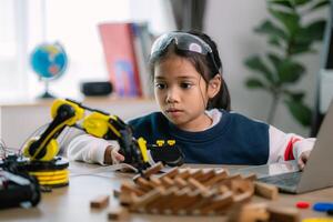 asiático muchachas fueron aprendizaje robot programación y consiguiendo lecciones controlar en robot brazos. laboratorio. matemáticas, ingeniería, ciencia, tecnología, computadora código, codificación. vástago educación. foto