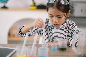 asiático niño niña aprendizaje Ciencias química con prueba tubo haciendo experimentar a colegio laboratorio. educación, ciencia, química, y para niños conceptos. temprano desarrollo de niños. foto