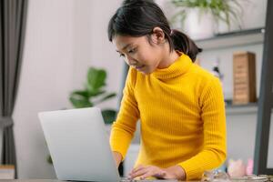 A young girl is sitting at a desk with a laptop in front of her photo