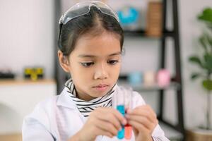 asiático niño niña aprendizaje Ciencias química con prueba tubo haciendo experimentar a colegio laboratorio. educación, ciencia, química, y para niños conceptos. temprano desarrollo de niños. foto