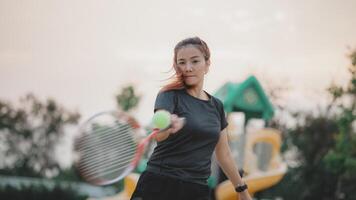 A woman is playing tennis with a tennis ball photo