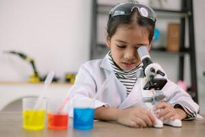 asiático niño niña aprendizaje Ciencias química con prueba tubo haciendo experimentar a colegio laboratorio. educación, ciencia, química, y para niños conceptos. temprano desarrollo de niños. foto