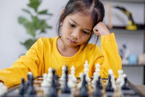 A young girl is playing a game of chess photo